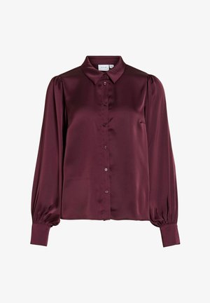 Pitkähihainen satiinipusero syvän viininpunaisena, klassisella kauluksella, napillisen edustan, laskostetut pömppöolkapäät ja kalvosimet.