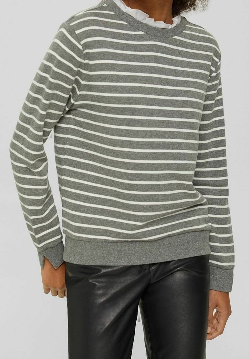 Grauer Pullover mit weißen horizontalen Streifen, geripptem Rundhalsausschnitt und Bündchen. Wird mit schwarzen Lederhosen getragen. Weiches Baumwollmaterial.