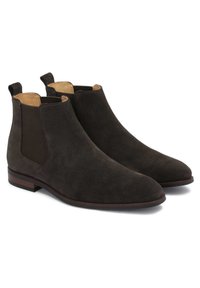 Chelsea-stövlar i mocka i mörkbrunt, med elastiska sidoskenor, dragflikar och en slank spetsig tå. Klassisk design med diskreta texturer.