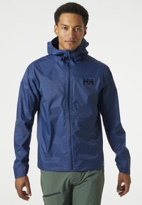 Navyblauwe waterdichte jas met een capuchon, voorzien van een voormezipper en het logo "HH" op de borst. Gemaakt van een gestructureerd, lichtgewicht materiaal.