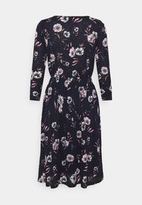 Marinblommig klänning med långa ärmar, med vita och rosa blommönster, en smal midja och en utsvängd kjol. Mjuk, lätt tyg.