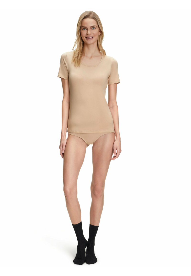Beżowa, dopasowana koszulka z krótkim rękawem, gładki materiał, okrągły dekolt, w zestawie z pasującymi majtkami od bikini i czarnymi skarpetkami na kostki.