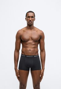 Fekete pamut boxeralsó márkás derékrésszel. Az szabás testhezálló, sík varrásokkal és sima felülettel. Nincs rajta további minta.
