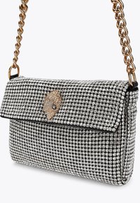 Sac à épaule orné de cristaux avec une base en tissu noir, bandoulière en chaîne dorée et un fermoir décoratif avec un motif d'œil.