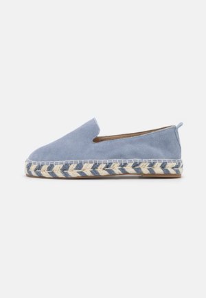 Espadrille bleu clair à enfiler avec tige en suède et semelle en jute tressée, semelle extérieure plate en caoutchouc, et languette à l'arrière du talon.