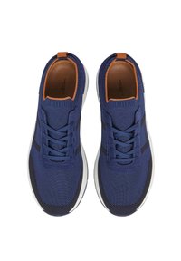 Zapatillas azul marino con tejido texturizado y paneles de malla, con acentos marrones, cordones redondos y una suela blanca. El diseño es deportivo y moderno.