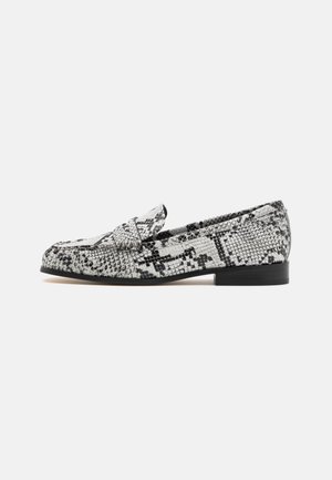 Mocassins à imprimé serpent avec un design texturé noir et blanc, bout arrondi et un petit talon noir. Agrémentés d'une petite sangle.