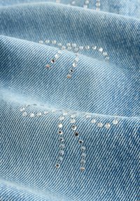 Svijetloplavi denimski materijal s suptilnim uzorkom malih, reflektirajućih kristalića raspoređenih u dekorativnom dizajnu.