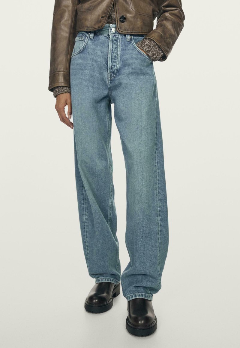 Light blue wide-leg jeans with a high waist, made of denim. Features a classic five-pocket design and subtle fading. Worn with black ankle boots.