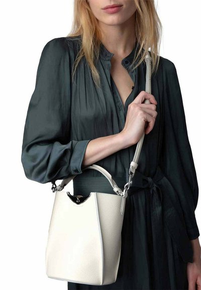 White leather bucket bag with silver hardware and a curved top. Features an adjustable strap, soft texture, and a minimalist design.