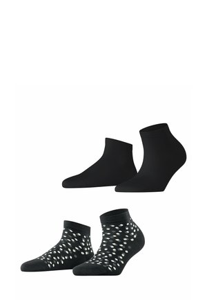 Schwarze Knöchelsocken und ein Set mit gemusterten Socken, das aus einfarbig schwarzem Stoff und einem schwarzen Grund mit weißen Punktmustern auf dem unteren Paar besteht.