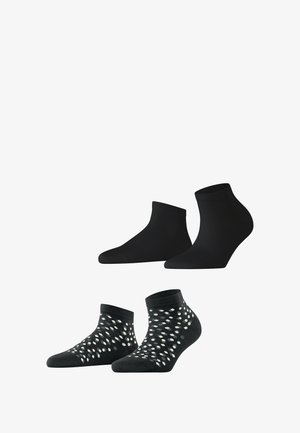 Schwarze Knöchelsocken und ein Set mit gemusterten Socken, das aus einfarbig schwarzem Stoff und einem schwarzen Grund mit weißen Punktmustern auf dem unteren Paar besteht.