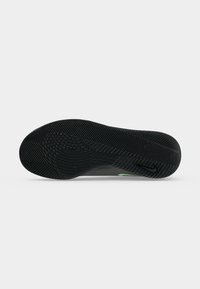 Μαύρη σόλα παπουτσιού Nike με υφασμένο μοτίβο πέλματος και μικρό μαύρο λογότυπο Nike swoosh κοντά στη φτέρνα.