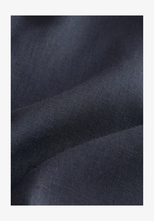 Tmavosivá ľanová látka s hladkým, textúrovaným povrchom, ktorá má jemný vzor tkania a mäkký záhyb.