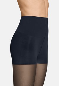 Hochtaillierte schwarze formende Shorts mit durchsichtigen braunen Strumpfhosen darunter. Das Material wirkt glatt, mit einem nahtlosen Design für einen schlanken Look.