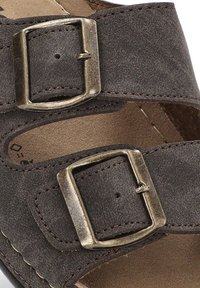 Sandalia de ante marrón con dos correas ajustables y hebillas metálicas. Suave forro interior y plantilla color beige, con costuras precisas.