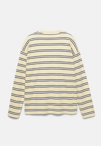 Camicia a maniche lunghe color crema con strisce orizzontali nere e bianche, mostrata distesa con la parte posteriore rivolta verso l'alto su sfondo bianco.