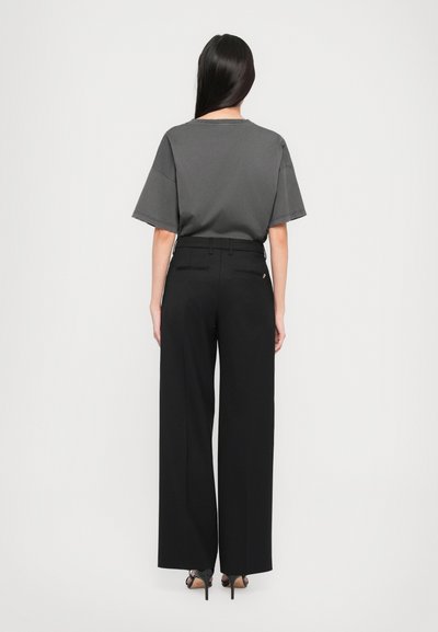 Gray short-sleeve top paired with black wide-leg trousers, featuring a smooth texture and clean lines, with no visible patterns or hardware.
