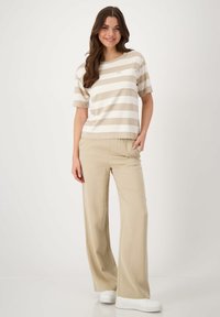 Beige and white striped short-sleeve top paired with beige wide-leg trousers. Soft fabric, relaxed fit, and side pockets in the pants.