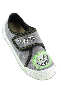 Baskets en tissu gris avec une sangle en Velcro, dotées d'accents en fil vert et d'un design de monstre brodé sur le bout avec une expression malicieuse.