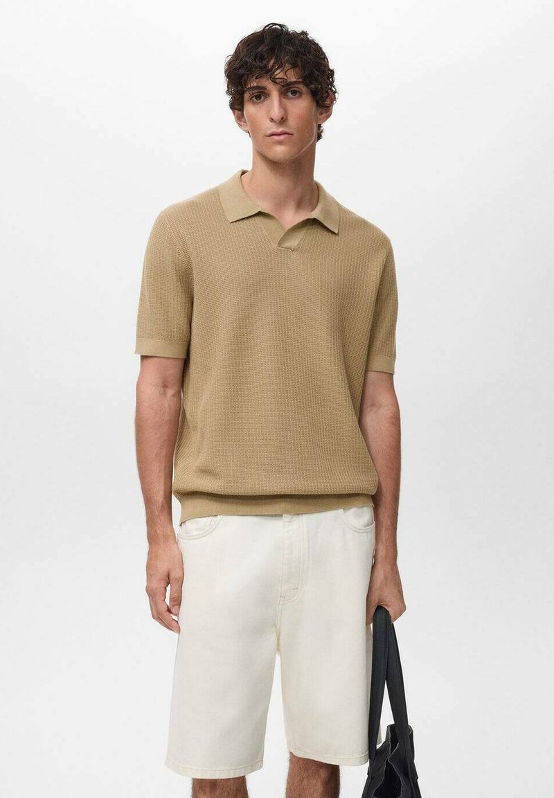 Beige knitted polo shirt with short sleeves, paired with white denim shorts. The outfit is complemented by a black bag.