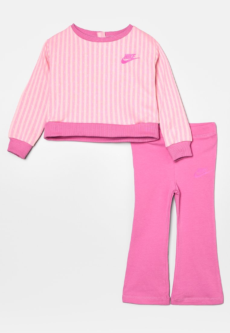 Top corto de manga larga a rayas rosas con cuello redondo y pantalones acampanados rosas a juego, ambos con el logo de Nike en un tono rosa más oscuro.