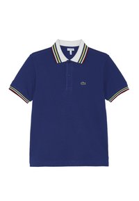 Blå polo-shirt i strukturerad tyg. Har en vit krage med röda, gröna och gula ränder, en placket med två knappar och en grön logotyp.