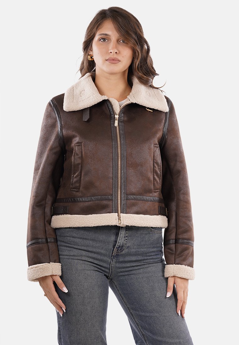 Chaqueta de imitación cuero marrón con cuello y puños de borrego, cierre de cremallera en la parte delantera, bolsillos laterales y detalles de panel oscuro en contraste.