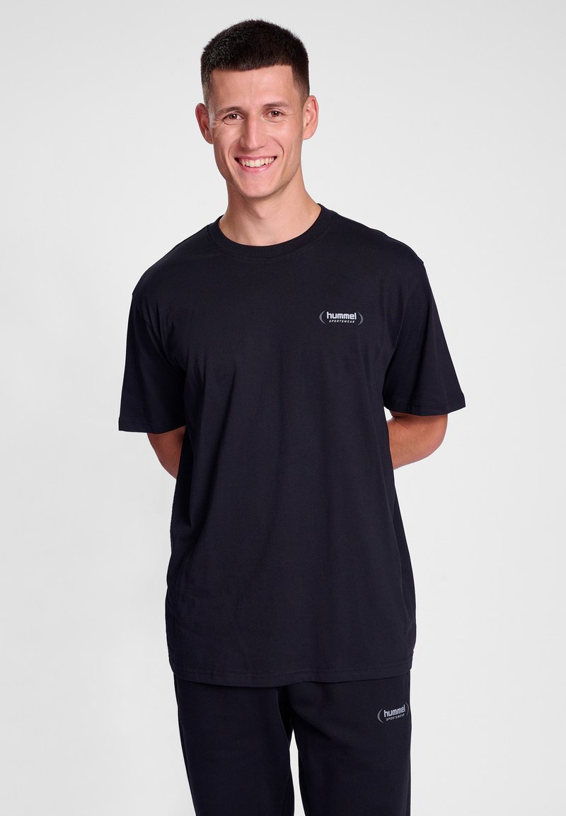 Black short-sleeve T-shirt made of cotton, featuring a round neck and small "hummel" logo in white on the chest. Smooth texture.