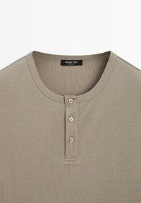Beige buttoned Henley shirt with three buttons and round neck collar, featuring Massimo Dutti label.