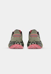 Αθλητικά παπούτσια με πράσινη πλέξη στην επάνω πλευρά, κόκκινες λεπτομέρειες και μια μοτίβο μαύρη και μπεζ ελαστική σόλα. Διαθέτουν υφή και ευέλικτο σχέδιο.