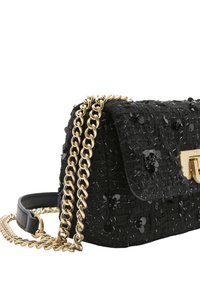 Czarna torebka z teksturą i cekinami, z klapkowym zapięciem oraz złotym łańcuszkowym paskiem. Charakteryzuje się prostokątnym kształtem i metalowymi elementami.
