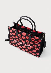 Black handbag with red kiss prints and white "VALENTINO" text. Features leather handles, a zip closure, and a detachable shoulder strap.