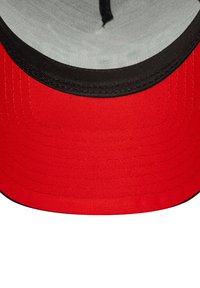 Cappello da baseball rosso con visiera nera, caratterizzato da una texture di tessuto liscia e un rivestimento interno grigio. Cuciture visibili lungo i bordi.