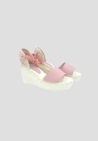 Espadrilles de cuña rosa con parte superior de cuero suave y lazos de tela trenzada en el tobillo. Presenta una entresuela de yute texturizado y suela plana de goma.