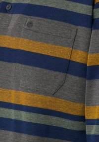 Stribet kortærmet skjorte med grå, marineblå, sennepsgul og grønne striber. Indeholder en stofflomme og to knapper nær kraven.