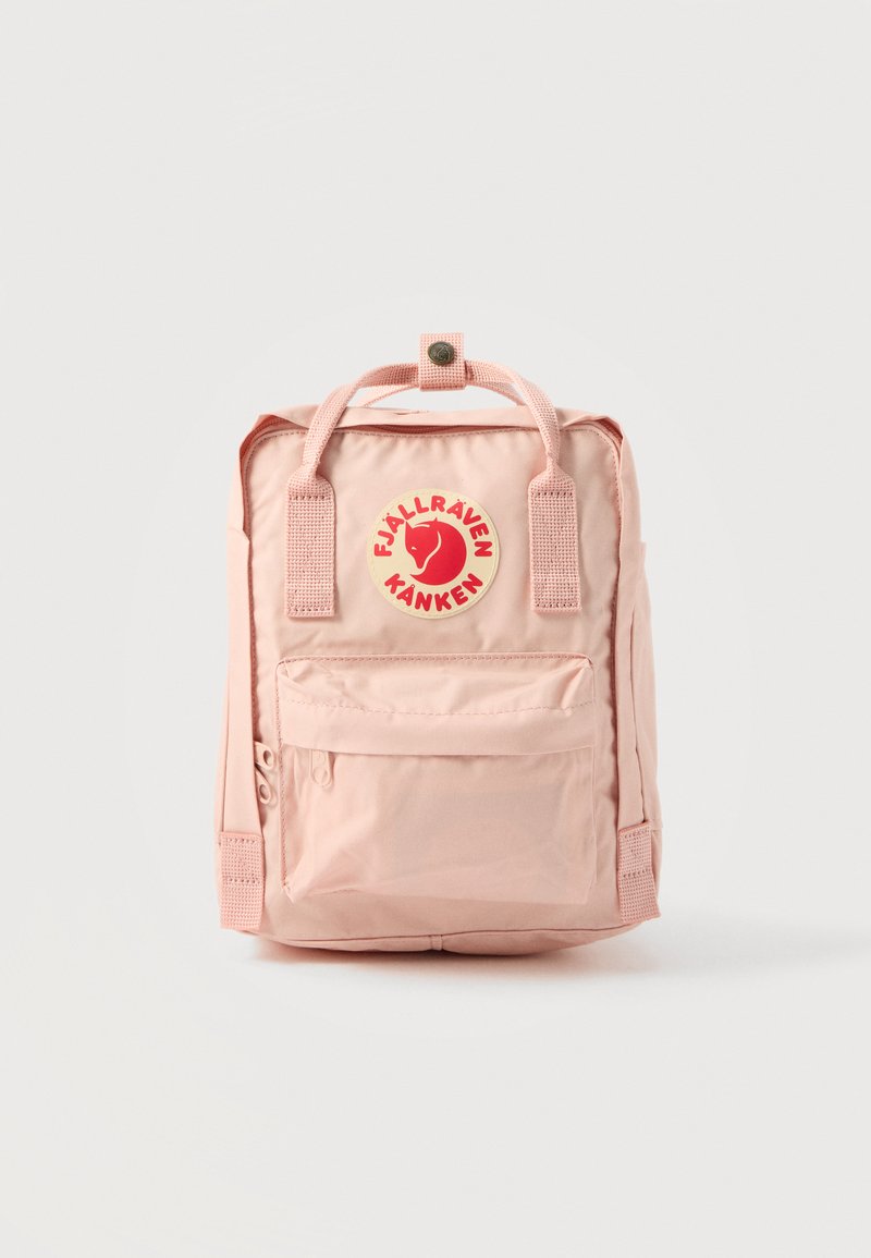 Hele roosa ristkülikukujuline seljakott esimesest lukuga taskust, kahekordsete ülemiste käepidemetega ja keskel punase ringikujulise logomärgiga, millel on rebane.