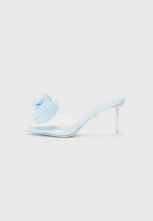 Blue patent leather slide sandal with a transparent strap, featuring a soft blue fabric flower accent and a clear heel.