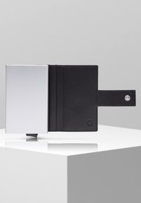 Portafoglio in pelle nera con portacarta in alluminio, caratterizzato da una finitura testurizzata, una chiusura a scatto laterale, tre slot per carte e un design minimalista.