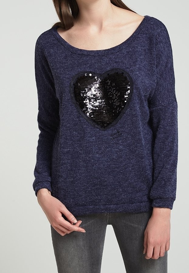 Mörkblå stickad tröja med en oversized svart paljett-hjärtdesign på framsidan. Har långa ärmar och en vid halsringning.