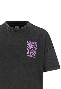 Zwarte t-shirt in een relaxte pasvorm, gemaakt van katoen met een ronde hals. Heeft een paarse spiraalafbeelding op de linkerkant van de borst.