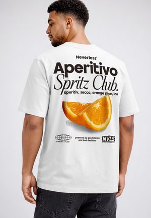 Man facing away wears white T-shirt with large text "Aperitivo Spritz Club" and an orange slice graphic on the back.