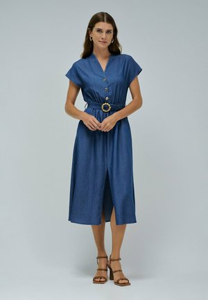 Vestido de denim con mangas cortas, botones en la parte delantera, cintura elástica y hebilla circular. Presenta un corte a media longitud y una abertura en la parte delantera.