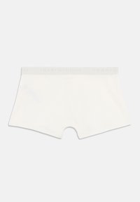 White cotton boxer briefs with a soft elastic waistband featuring the "TOMMY HILFIGER" logo in light gray. Smooth texture and fitted design.