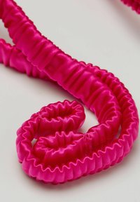 Fuchsia Satinband mit geriffelter Textur, spiralförmig gewunden, mit glänzender Oberfläche und weichem, glattem Erscheinungsbild.