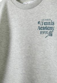Szara bluza z miękkiego materiału, z ribbowanym dekoltem, ozdobiona nadrukiem "Los Angeles Tennis Academy 1997" oraz motywem rakiety tenisowej.