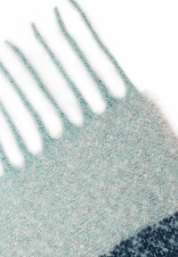 Woven scarf with a gradient from light blue to dark blue, featuring a soft texture and fringed edges. Pattern is subtle and blended.
