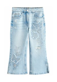 Ljusblå denimjeans med fjärilsbroderi, slitna detaljer och utsvängd form. Har framfickor och knäppning med knapp.