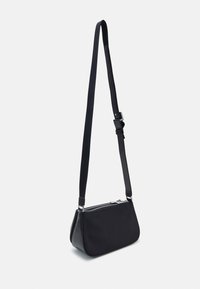 Borsa a tracolla nera realizzata in tessuto e ecopelle. Presenta una forma elegante e allungata, tracolla regolabile e chiusura zip in metallo argento.