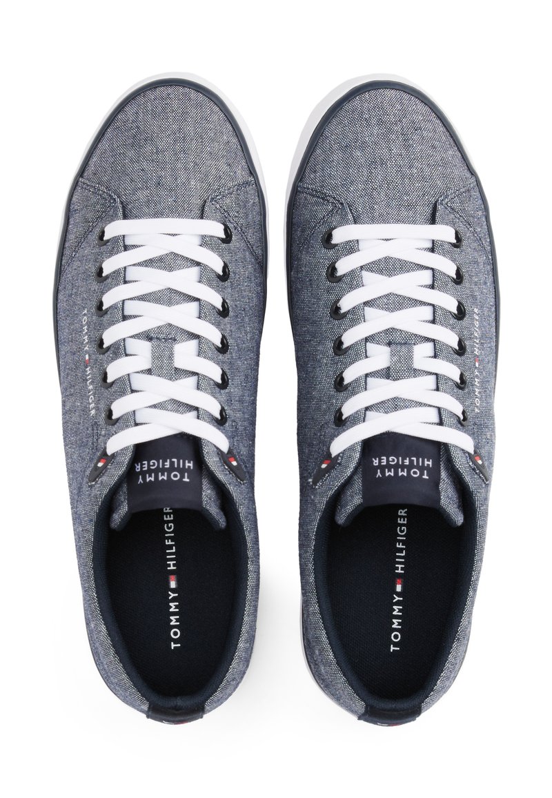 Baskets en toile bleu foncé avec des lacets blancs, bout rond, doublure noire et semelle intérieure signée avec le logo Tommy Hilfiger.